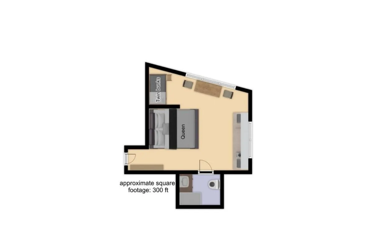 This image displays the core living area of the studio, featuring a queen bed, twin bunk beds, a cozy sofa, and a kitchenette. The arrangement highlights how the space is designed for both relaxation and communal activities, with plenty of natural light illuminating the room. The bunk beds are visible and positioned to showcase their family-friendly, flexible use.